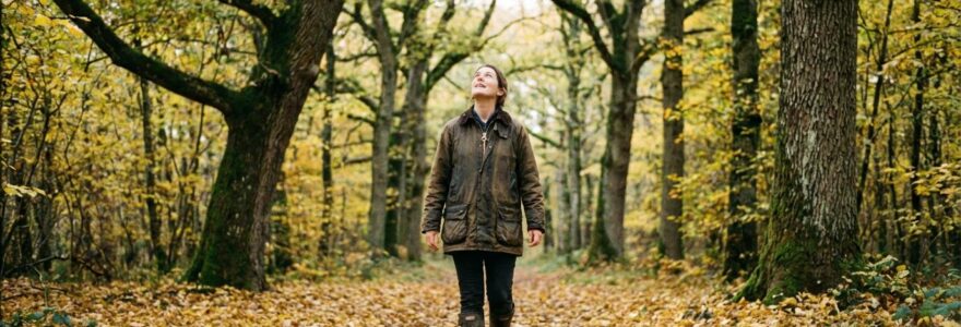 Futur acquéreur parcourant une allée forestière de chênes en observation du domaine